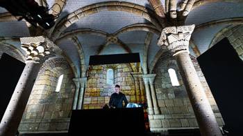 A man performs his choral work inside a piston-shaped stone temple